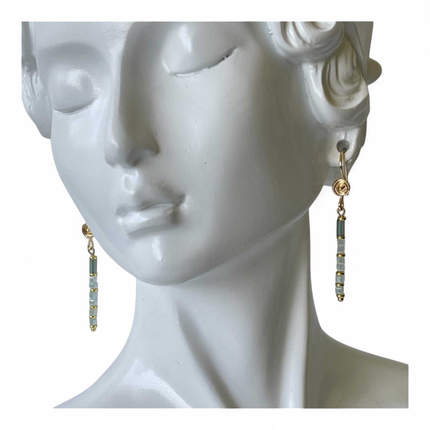Simple drop earrings accented with blue beads in gold color