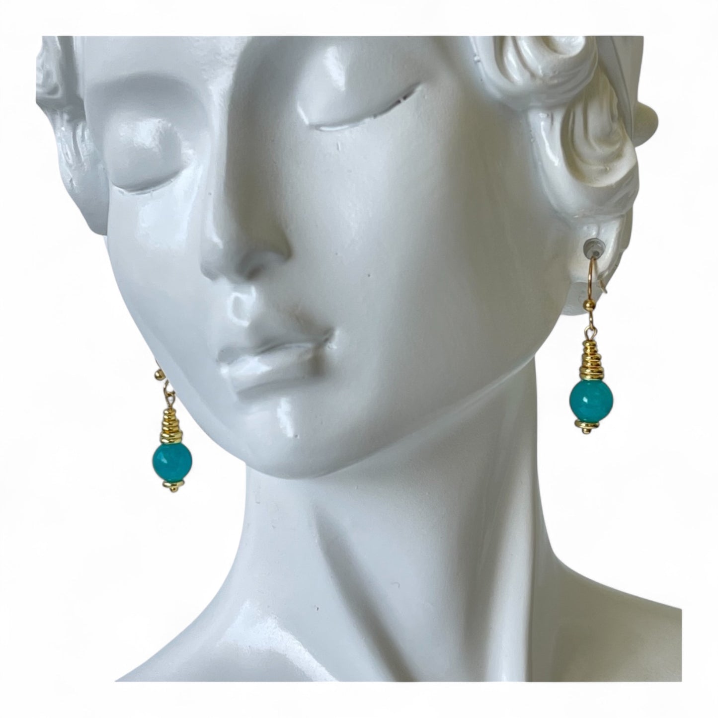 Gold earrings accented with green color bead